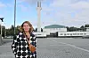 Tuula Lahti står på ett stenlagt torg framför Aalto-centret i Seinäjoki.