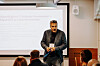 Mattias Lindroth presenterar framför en projektorduk för en sittande publik.