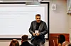 Mattias Lindroth presenterar framför en projektorduk för en sittande publik.