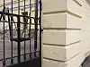 Svart järngrind vid en ljus putsad byggnad som tillhör École Française Jules Vernes.