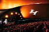 Publikhav framför en upplyst konsertscen på Huvila, med en stor Huvila-logotyp på taket.