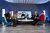 Fyra personer deltar i en paneldiskussion i en upplyst tv-studio.